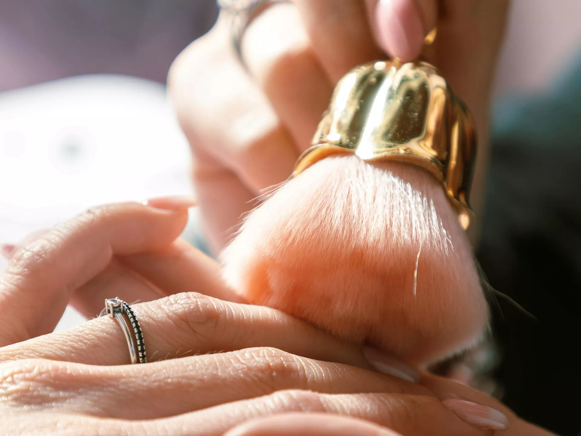 Manos y pincel de maquillaje